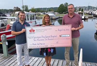 Derek Lubert and Dave Rozycki holding a cheque for $10600 addressed the the Georgian Bay General Hospital